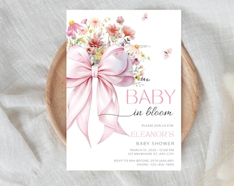 Puede incluir: Una invitación de baby shower rosa con una ilustración de acuarela de un lazo rosa y un ramo de flores. El texto dice "Baby in Bloom" e incluye detalles para la baby shower de Eleanor.