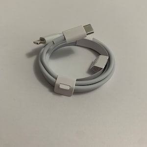 May include: White USB-C to Lightning cable coiled and wrapped in white packaging.
