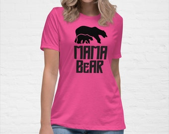 May include: A pink t-shirt with a black silhouette of a mama bear and two cubs. The text "MAMA BEAR" is printed in black below the bears.