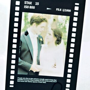 Pode incluir: Design de faixa de filme preta com uma foto de casamento. A faixa de filme tem o texto "STAX 15 ISO 800 F5.6 1/1000". A foto mostra um casal em trajes formais. O texto na parte inferior diz: "Pessoas que gostam de tirar fotos realmente querem guardar aquele belo momento..."