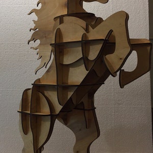 May include: A wooden horse sculpture with a cutout design, creating shelves for storage. The horse is standing on its hind legs with its front legs raised. The horse is made of light brown wood and has a flowing mane.