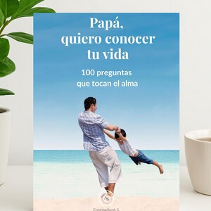Op de afbeelding: Een wenskaart met de tekst "Papá, quiero conocer tu vida" en "100 preguntas que tocan el alma" tegen een achtergrond van blauwe lucht en oceaan. De afbeelding toont een vader en kind die op het strand spelen. De kaart heeft het logo "CounsellorA.S."