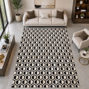 May include: A rectangular area rug featuring a repeating geometric pattern of black and cream-colored hexagons. The rug is positioned on a light-colored floor in a room with a sofa, an armchair, and various pieces of furniture.