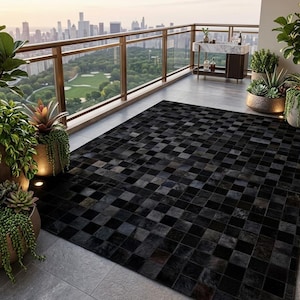 May include: A rectangular area rug featuring a black and dark gray checkered pattern made of square tiles. The rug is positioned on a gray tiled floor, surrounded by various potted green plants and succulents in metallic containers.