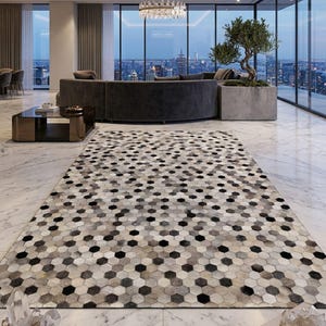 Peut inclure: Un grand tapis avec un motif géométrique de formes hexagonales noires, grises et blanches. Le tapis est posé sur un sol en marbre dans un salon moderne. La pièce comprend un canapé incurvé, de grandes fenêtres et une vue sur la ville.