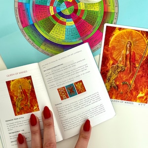 May include: A tarot card reading guide with a close-up of the Queen of Wands card. The card features a woman holding a staff with a fiery background. The guide includes information about the card's meaning and symbolism.