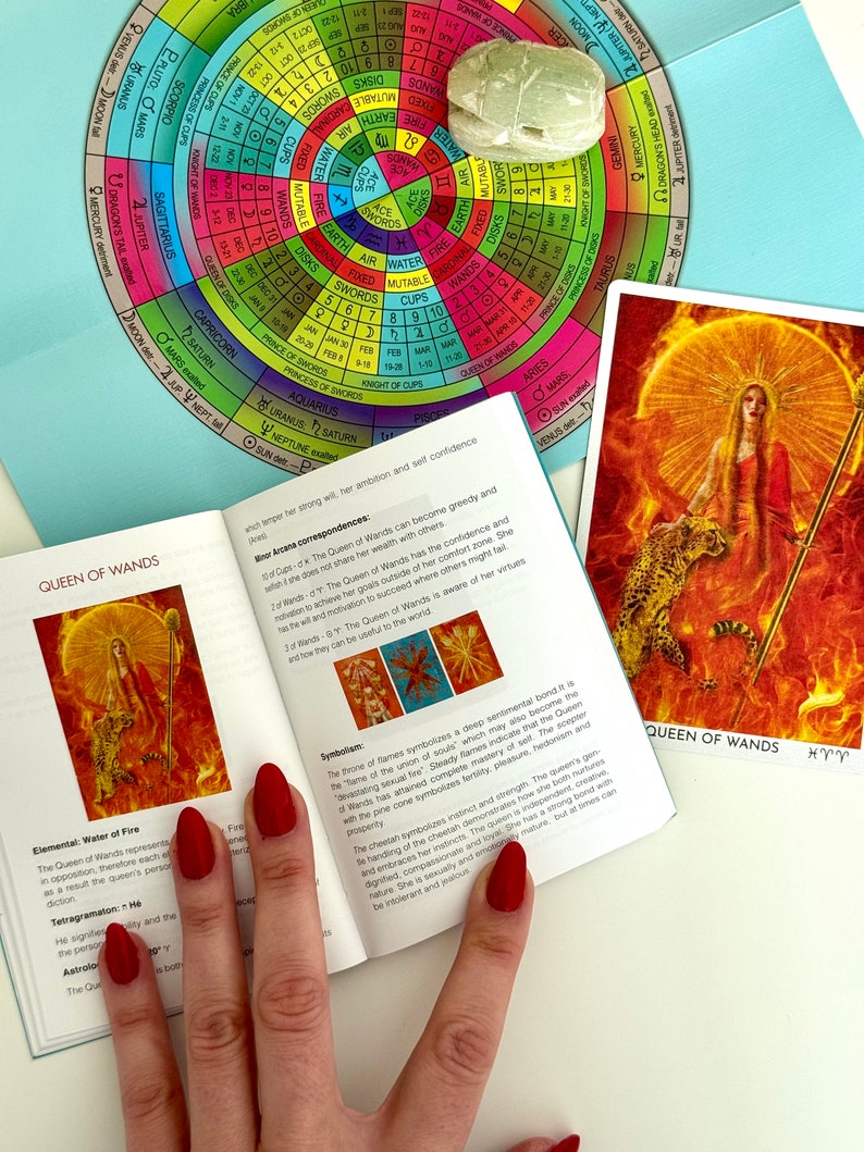 May include: A tarot card reading guide with a close-up of the Queen of Wands card. The card features a woman holding a staff with a fiery background. The guide includes information about the card's meaning and symbolism.