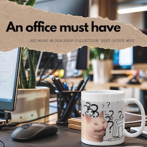 Pode incluir: Caneca de cerâmica branca com uma imagem de meme de gato. O gato está olhando para uma tela de computador com pontos de interrogação. O texto na caneca diz "??".