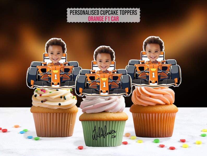 May include: Three cupcakes topped with personalized orange F1 car toppers featuring a child's face. The cupcakes have different frosting colors and sprinkles. The text "PERSONALISED CUPCAKE TOPPERS ORANGE F1 CAR" is at the top.