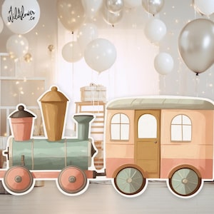 Op de afbeelding: Waterverfillustratie van een speelgoedtrein en een passagierswagen in pastelkleuren. De trein is lichtgroen met perzikwielen en de wagen is perzik en bruin. De achtergrond bevat ballonnen en de tekst "wildflower.co".