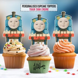 May include: Three cupcakes with Thomas the Tank Engine toppers. The cupcakes have different coloured frosting: white with sprinkles, pink, and orange. The text "PERSONALISED CUPCAKE TOPPERS TRAIN TANK ENGINE" is at the top.