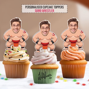 以下が含まれることがあります： 相撲レスラーのパーソナライズされたトッパーが付いた3つのカップケーキ。トッパーは、相撲レスラーの衣装を着た男性の漫画の画像です。カップケーキはさまざまな色のフロスティングで、スプリンクルで飾られています。「Personalised Cupcake Toppers Sumo Wrestler」というテキストが上部にあります。
