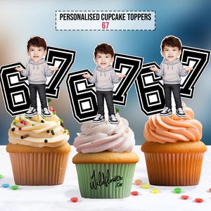 Puede incluir: Tres cupcakes con adornos personalizados. Cada adorno presenta una imagen de dibujos animados de un niño y el número 67 en un diseño en blanco y negro. Los cupcakes tienen glaseados de diferentes colores y están decorados con chispas.
