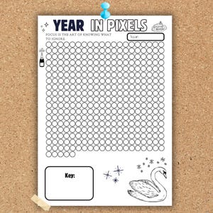 May include: A black and white Year in Pixels tracker sheet featuring a grid of circles, a champagne bottle, a slice of cake, and a swan illustration. The text reads: Year in Pixels, Focus is the art of knowing what to ignore, Year, and Key.