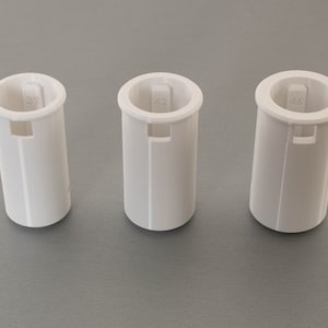 May include: Three white plastic tubes with different numbers printed on them. The numbers are 33, 42, and 48.