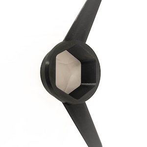 May include: A black, hexagonal socket wrench with two wing-like extensions. The tool is designed for tightening or loosening bolts and nuts. The wrench is made of a solid, matte black material and is set against a white background.