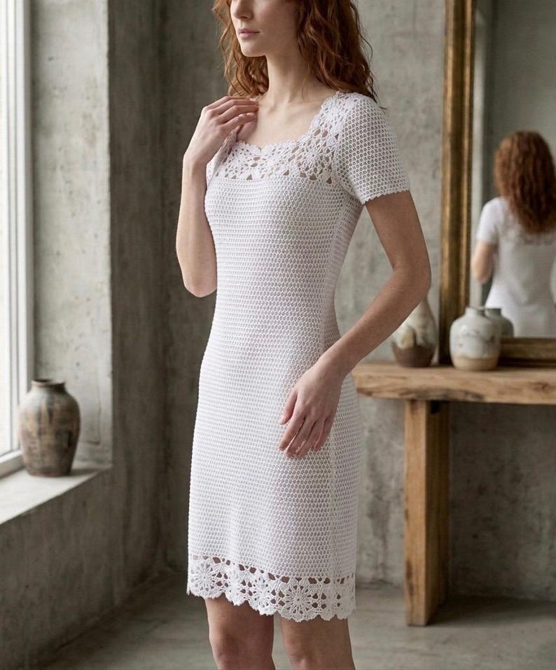May include: A white crochet dress with a square neckline and short sleeves. The dress features a detailed crochet pattern around the neckline and hem. The dress is knee-length and form-fitting.