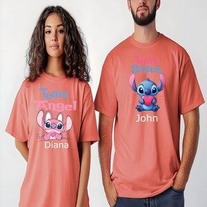 Puede incluir: Dos camisetas color coral con personajes de dibujos animados. Una muestra "Team Angel" y "Diana", con un personaje rosa. La otra muestra "Team Stitch" y "John", con un personaje azul sosteniendo un coraz&oacute;n. Para parejas.