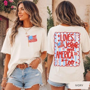 A woman wearing a white t-shirt with an American flag design and text on the back.