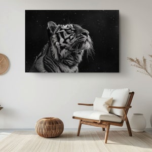 Puede incluir: Una fotograf&iacute;a en blanco y negro de un tigre mirando hacia arriba con un fondo nevado.