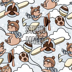 Peut inclure: Motif répétitif avec des oursons de dessin animé portant des lunettes d'aviateur et des écharpes, pilotant des avions et tenant des ballons. Les ours sont bruns avec des accents bleu clair et blancs, sur fond bleu clair avec des étoiles et des nuages blancs. Le texte "STUDIO MALEO" est visible.