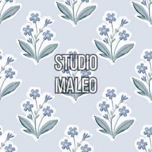 Peut inclure: Un motif répétitif de brins de fleurs bleues sur un fond bleu clair. Chaque bouquet présente des fleurs bleues à cinq pétales et des feuilles vertes avec un contour blanc. Le texte STUDIO MALEO est centré en gris foncé avec un contour blanc.