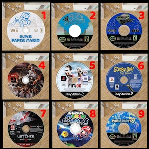 Op de afbeelding: Negen videospeldiscs met titels als "Super Paper Mario" voor Wii, "Sonic 2 Adventure" voor Sega en "FIFA 06" voor PlayStation 2. Andere titels zijn "Scooby-Doo! First Frights" en "Mario Party 7".