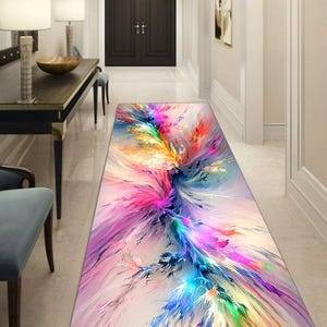 May include: A rectangular hallway rug with a vibrant abstract design. The rug features a burst of colors, including pink, blue, yellow, and green, creating a dynamic and artistic visual effect. The design is reminiscent of an explosion of paint.