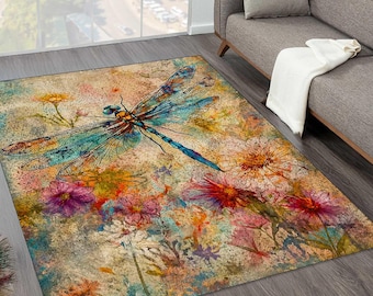 Puede incluir: Alfombra rectangular con un diseño de acuarela de una libélula y flores en tonos azules, naranjas, rosas y amarillos. La alfombra tiene un aspecto envejecido y vintage, con un fondo neutro. La alfombra está colocada sobre un suelo de madera.