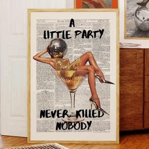 May include: A framed art print with the text "A Little Party Never Killed Nobody." The artwork features a woman in a gold dress and a disco ball head, inside a martini glass. Two other framed prints are visible in the background.