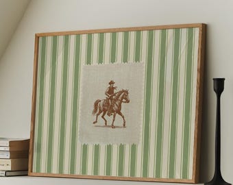May include: A framed print with a green and white striped background. The print features a brown horse and rider in a brown and white saddle. The print is hanging on a white wall with two black candle holders on a shelf below.