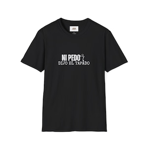 May include: Black t-shirt with white text that reads "NI PEDO DIJO EL TAPADO" with a stick figure illustration.
