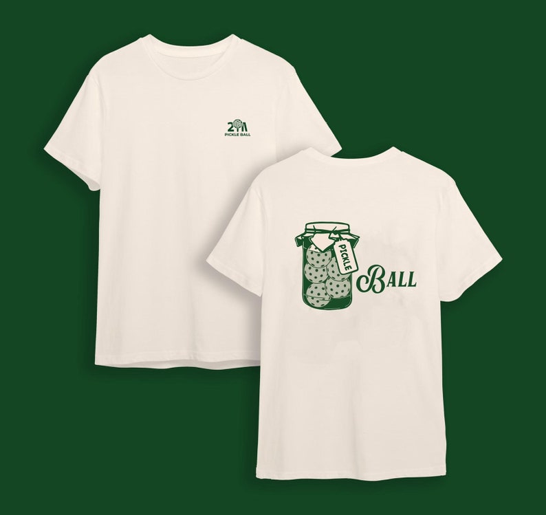 May include: Off-white t-shirts with green graphics. One shirt has a small logo on the front, the other features a jar of pickles with a tag that says "Pickle" and the word "Ball".