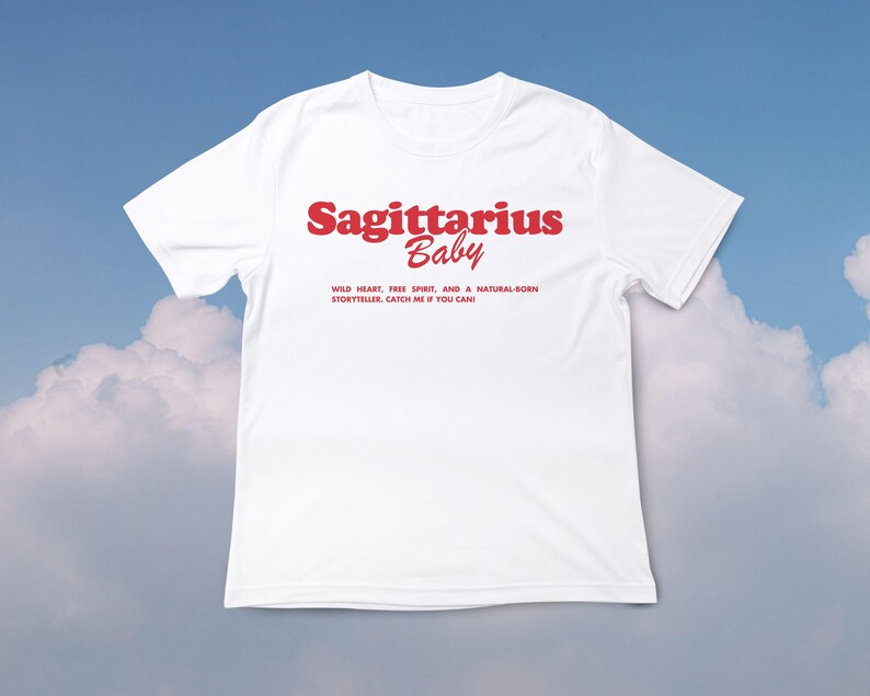 May include: White t-shirt with red text that says "Sagittarius Baby" and "Wild heart, free spirit, and a natural-born storyteller, catch me if you can!"