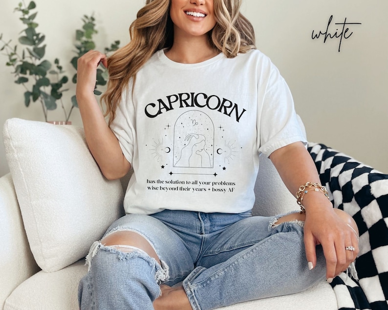 Puede incluir: Camiseta blanca con un gr&aacute;fico negro de un signo zodiacal de Capricornio y el texto "CAPRICORN has the solution to all your problems wise beyond their years - bossy AF".