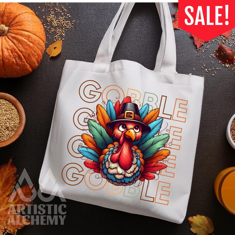 May include: A white canvas tote bag featuring a colorful illustration of a turkey wearing a black pilgrim hat. The turkey has vibrant red, blue, orange, and green feathers. The text GOBBLE GOBBLE is printed in a large, outlined font behind the turkey.