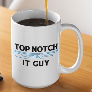 May include: White ceramic coffee mug with a blue circuit board design and the text "Top Notch IT Guy".