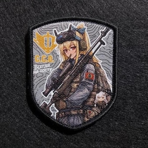 Puede incluir: Parche bordado con una ilustración de estilo anime de un personaje femenino con uniforme militar, sosteniendo un rifle. El parche en forma de escudo incluye texto en ruso y un emblema dorado sobre un fondo gris texturizado.