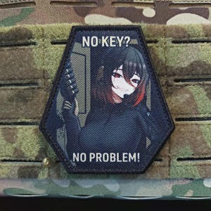 May include: A black and navy blue hexagonal patch with the text "NO KEY?" above an anime-style illustration of a person holding a weapon. The text "NO PROBLEM!" is below the illustration. The patch is on a camouflage background.