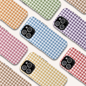 May include: A collection of phone cases in various colors, each featuring a classic gingham pattern. The cases are in shades of orange, green, pink, blue, purple, brown, yellow, and red. The cases have a black border and a camera cutout.