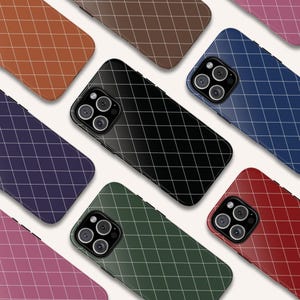 Può includere: Una collezione di custodie per telefoni colorate con un motivo a griglia. Le custodie sono disponibili in vari colori, tra cui marrone, nero, blu, verde, rosso e rosa. Ogni custodia ha un modulo fotocamera con tre obiettivi.