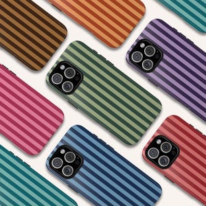 May include: A collection of colorful phone cases with a striped pattern. The cases are in various colors, including pink, green, blue, purple, and brown. Each case has a camera module with multiple lenses.