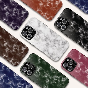 May include: A selection of smartphone cases featuring a marble effect design. The cases are presented in a range of colours, such as white, black, brown, green, red, and blue. Each case has a glossy finish and a camera aperture.