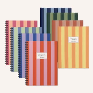 May include: A set of eight striped notebooks with different color combinations. The notebooks have spiral bindings and feature the names "Andrew" and "Jackson" on the covers.