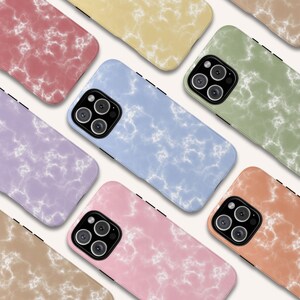 May include: A selection of smartphone cases in pastel shades such as pink, blue, green, and yellow. Each case displays a marble-effect pattern with white veining. The cases are arranged diagonally, highlighting the range of colour choices available.