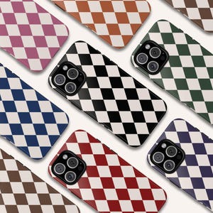May include: A collection of smartphone cases with a checkered pattern in various colors, including black and white, red and white, and blue and white. The cases have a glossy finish and a camera cutout.