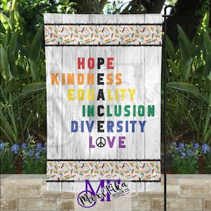 Puede incluir: Una bandera de jardín de madera blanca con un borde de patrón de arcoíris. La bandera presenta las palabras "HOPE", "KINDNESS", "EQUALITY", "INCLUSION", "DIVERSITY" y "LOVE" en colores arcoíris.