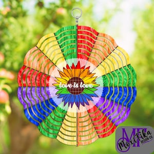 May include: A colorful wind spinner with a rainbow design and a sunflower in the center. The sunflower has the words "love is love" in the middle. The wind spinner is a decorative item for a garden or outdoor space.