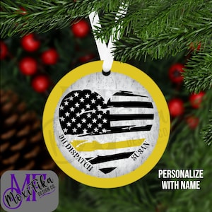 May include: A round Christmas ornament with a yellow border and a white ribbon. The ornament features a heart-shaped design with the American flag and the text "911 Dispatch" and "Susan". The words "Personalize with Name" are also visible.