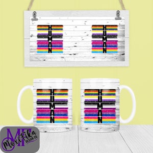 Puede incluir: Taza de cerámica blanca y estampado enmarcado con la palabra "HUMAN" en letras negras. Cada letra está rellena de rayas coloridas que representan diferentes banderas del orgullo. La taza y el estampado están sobre un fondo de madera blanca.